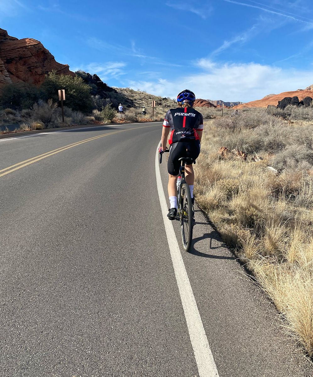 cyclist riding on the shoulder of a roadway